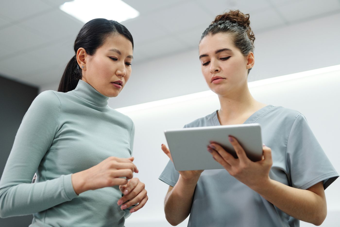 A patient and a health professional looking at a tablet together